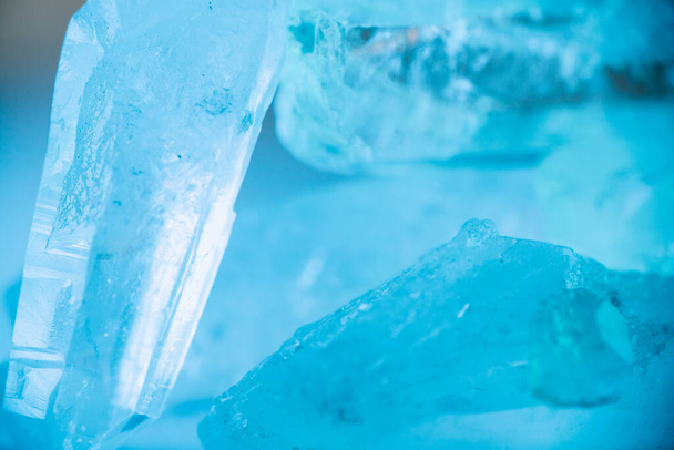  gemstone texture in blue light.transparent quartz crystals background in blue tones.crystals of natural transparent stone rock.Texture of natural stone Rock crystal - Φωτογραφία, εικόνα