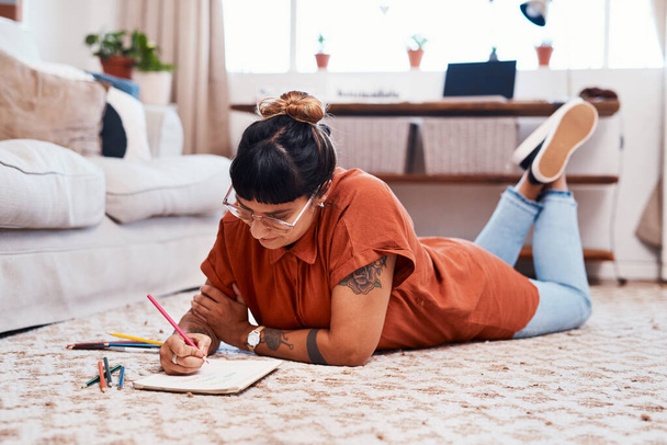 Getting older doesnt mean you have to stop being creative. a young woman using coloring pens while drawing at home - Fotoğraf, Görsel
