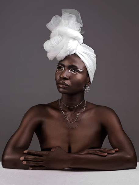 Beauty, fashion and black woman with makeup, thinking and confident against a grey studio background. Female person, girl and model with ideas, fantasy and feminine with fierce attitude and culture. - Foto, afbeelding