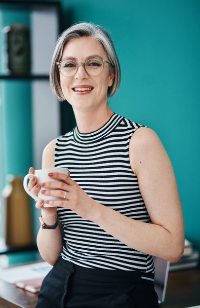Succes is aan de andere kant van angst. een volwassen zakenvrouw met koffie in haar kantoor - Foto, afbeelding