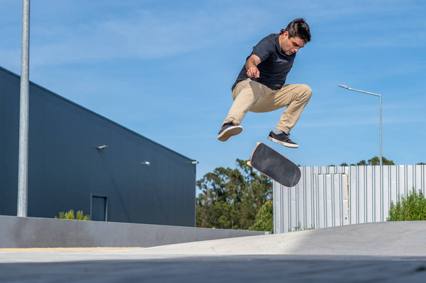 Skateboarder doing a flip trick  on a urban scene. - Fotó, kép