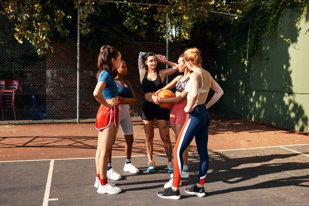 私たちはいつも話をしなければならない。日中一緒にバスケットボールの試合をした後に結合する多様なスポーツ女性のグループ - 写真・画像