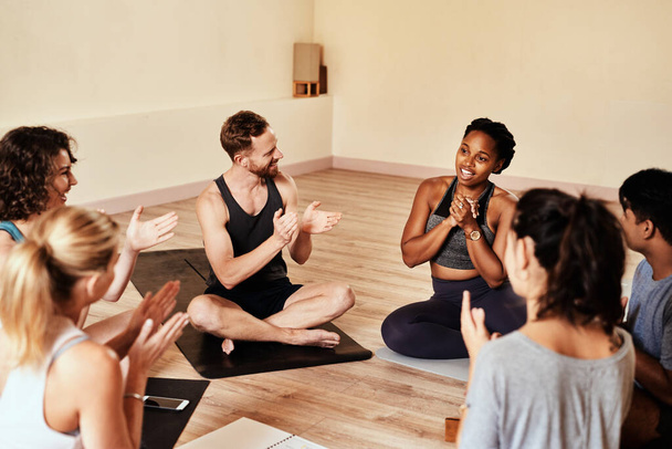 Нет ничего более заразного, чем мотивация. группа молодых мужчин и женщин хлопает во время урока йоги - Фото, изображение
