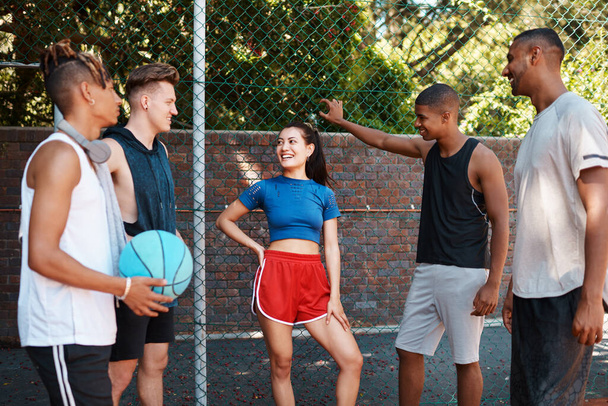 バスケットボールは彼らの共通の趣味です。スポーツコートでおしゃべりするスポーティな若者たちが - 写真・画像