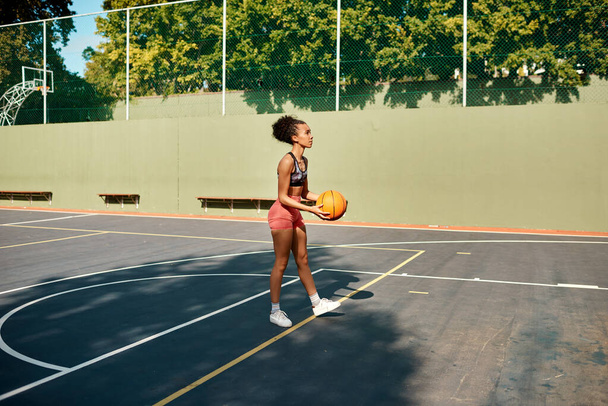 Mantén la cabeza en alto y dispara. una joven deportista jugando baloncesto en una cancha deportiva - Foto, Imagen