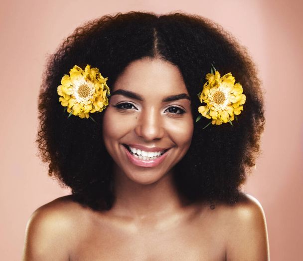 Πορτρέτο της χαρούμενης γυναίκας, αφρό και κίτρινα λουλούδια στο στούντιο φόντο για την ομορφιά, floral αισθητική και λάμψη. Πρόσωπο αφρικανικού μοντέλου, περιποίηση δέρματος και μαργαρίτα φυτά στα μαλλιά για την ευτυχία, άρωμα ή μακιγιάζ. - Φωτογραφία, εικόνα