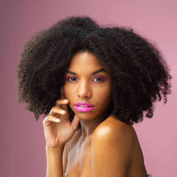 Face, hair care and serious black woman with makeup in studio isolated on a pink background for skincare. Hairstyle portrait, cosmetics and African female model with salon treatment for afro beauty - Photo, Image