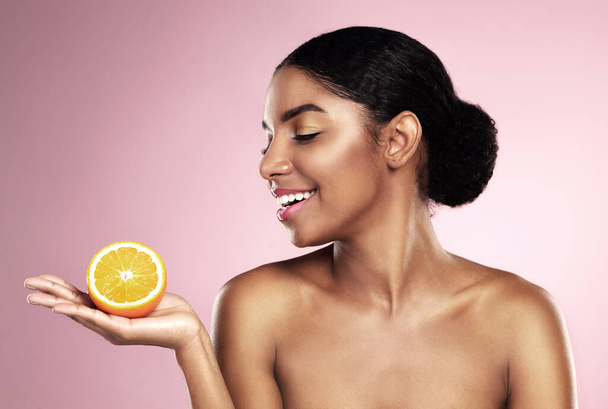 Happy woman, orange fruit and beauty in studio, pink background or wellness of healthy vitamin c cosmetics. African model, citrus and nutrition for natural facial skincare, organic benefits or mockup. - Fotoğraf, Görsel