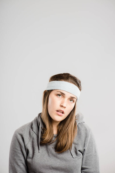 I dont get it. an attractive young woman sitting alone in the studio and posing while wearing a headband and feeling bored - Foto, Imagem