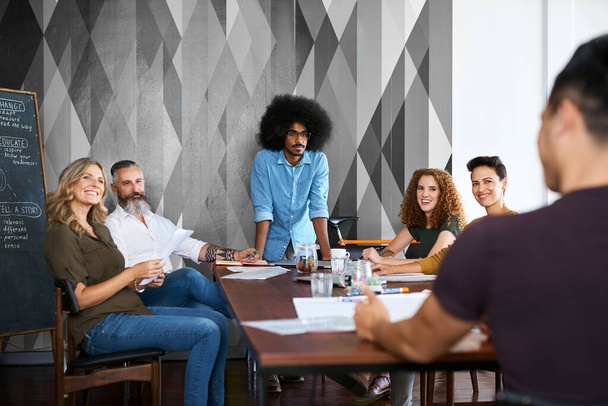 Traer sus ideas a la mesa. un grupo de diseñadores teniendo una reunión en su oficina creativa - Foto, imagen