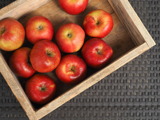 Fresh red organic apples in a wooden box after harvesting, seasonal food, agriculture concept - Valokuva, kuva