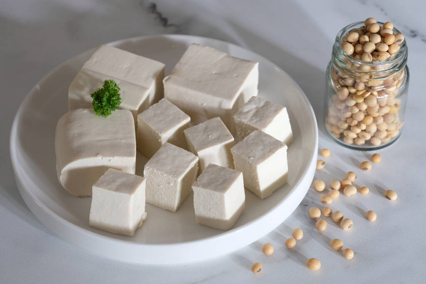tofu ou coalhada de feijão é um alimento tradicional feito de soja. tofu fatiado na placa de cerâmica branca. Tahu Putih. Soja no frasco de vidro. - Foto, Imagem