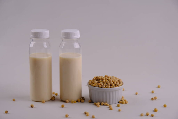 Susu Kedelai, soy milk served in  clear plastic bottles, containing vegetable protein, vitamin D, B12, calcium, omega 3. Suitable for vegans and vegetarians. Made from soybeans, water and sugar. - Fotó, kép