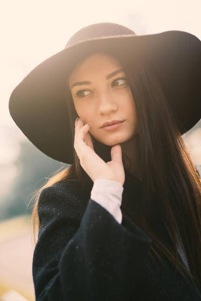 Beautiful woman portrait outdoors in a park wearing a vintage hat. - Photo, image