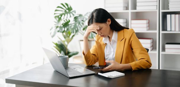 Asian businesswoman is stressed, bored, and overthinking from working with laptop at the office - Φωτογραφία, εικόνα