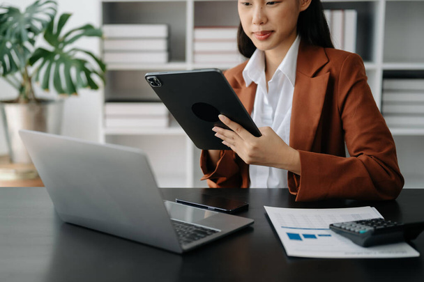 Businesswoman with tablet ,laptop computer with financial graphs and statistics at office - Foto, Bild