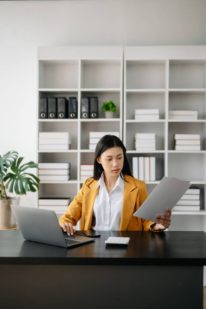 Empresaria asiática trabajando en la oficina con laptop y documentos  - Foto, Imagen