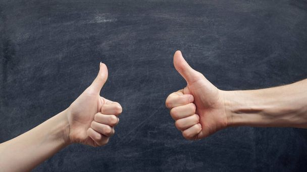 Like gesture. Approval sign. Man and woman hands showing thumb up on chalkboard background. - Foto, Bild