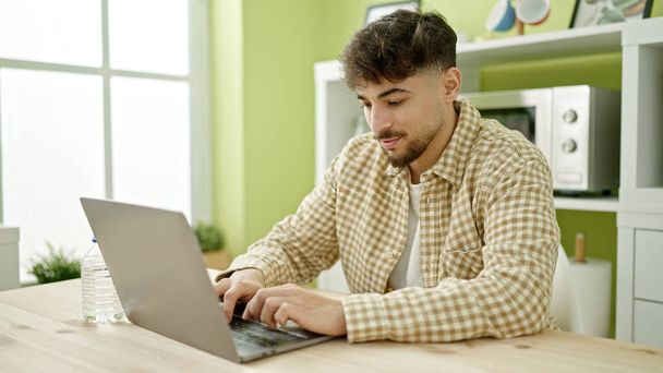 Young arab man using laptop sitting on table at home - Foto, Bild