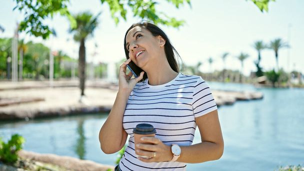 Женщина с Ближнего Востока говорит по телефону на берегу моря - Фото, изображение