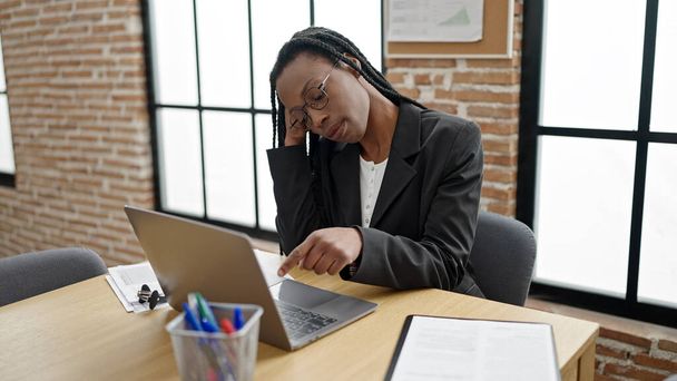 アフリカ系アメリカ人女性のビジネスマンがオフィスでノートパソコンを使って退屈 - 写真・画像