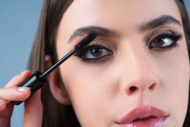 Perfect eyebrows. Close up of woman getting eyebrow make-up. Macro applying cosmetics on her eyebrow with brush. Perfect shape of eyebrow, brown eyeshadows and long eyelashes. Beauty concept - 写真・画像