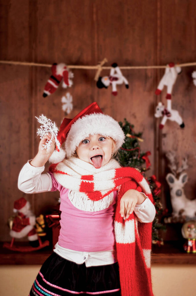 child in a suit of Santa Claus in the room decorated to new year - Фото, зображення