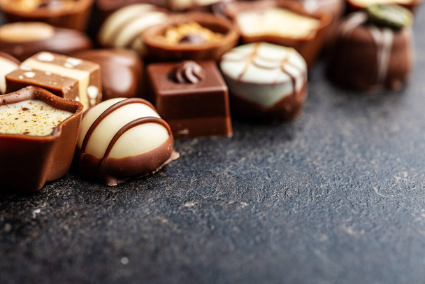 Sweet chocolate pralines.  Tasty chocolate truffles on the black table. - 写真・画像