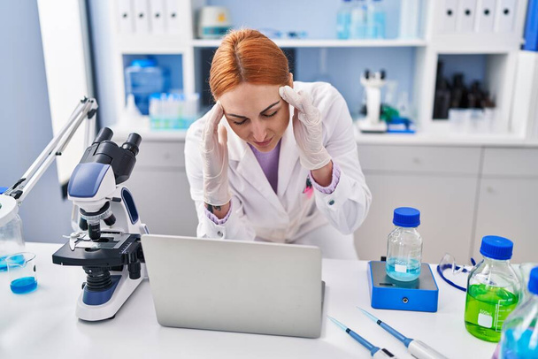 Mladá běloška žena vědec zdůraznil pomocí notebooku pracuje v laboratoři - Fotografie, Obrázek