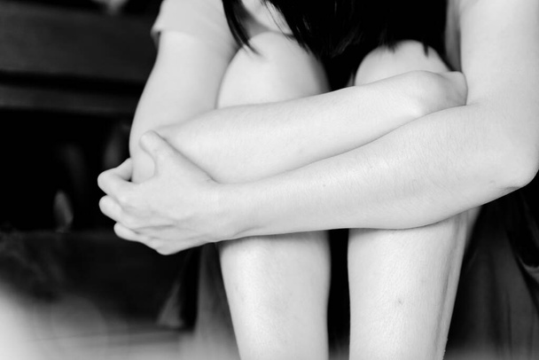 Vrouw knuffelt haar knieën in depressie vanwege haar slechte geestelijke gezondheid. Begrip geestelijk gezondheidsprobleem. - Foto, afbeelding