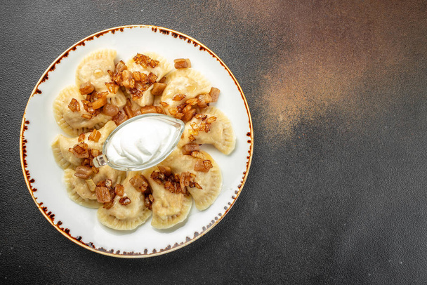Pierogi or pyrohy, varenyky, vareniki, dumplings served with caramelized salted onion. banner, menu, recipe place for text, top view. - Foto, Imagem