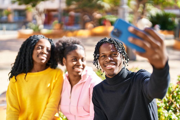 Αφροαμερικανοί φίλοι κάνουν selfie από το smartphone κάθεται στον πάγκο στο πάρκο - Φωτογραφία, εικόνα