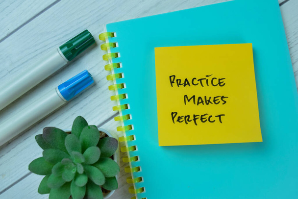 Concept of Practice Makes Perfect write on sticky notes isolated on Wooden Table. - Foto, afbeelding