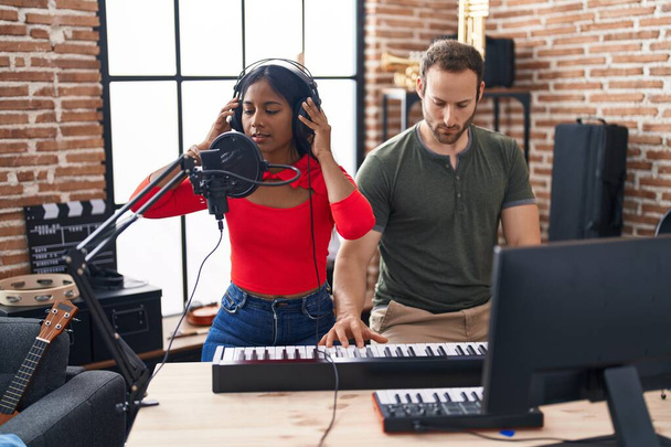 Homem e mulher músicos cantando música tocando piano no estúdio de música - Foto, Imagem