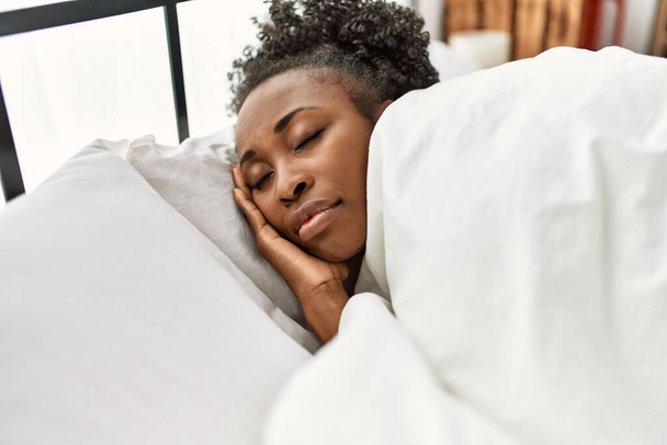 African american woman lying on bed sleeping at bedroom - Foto, Bild