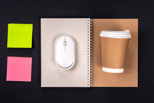 Σημειωματάριο, κύπελλο μιας χρήσης, ποντίκι και λευκό αυτοκόλλητα χαρτί για υπενθυμίσεις, πάνω άποψη. Έννοια εργασίας. - Φωτογραφία, εικόνα