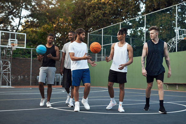 Pojďme si zastřílet ještě pár obručí. skupina sportovních mladých mužů, kteří se poflakují na basketbalovém hřišti - Fotografie, Obrázek