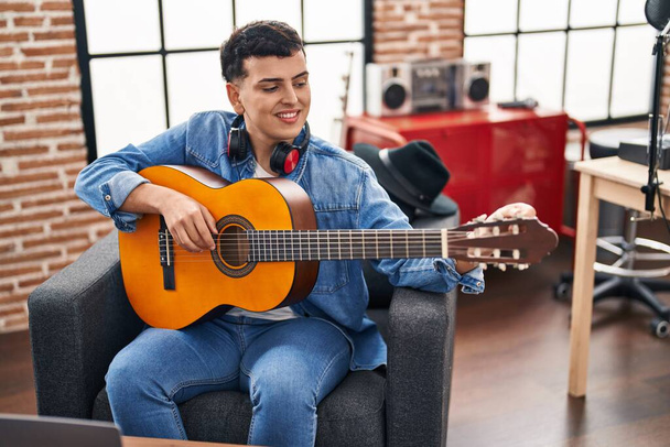 Jovem não binário homem músico tocando guitarra clássica no estúdio de música - Foto, Imagem