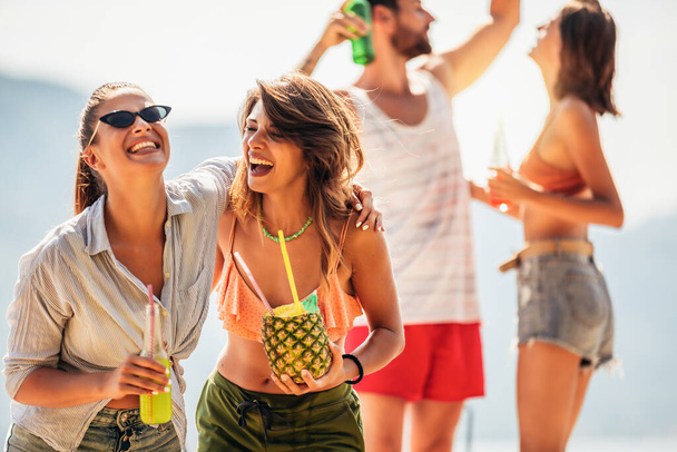 Молодые друзья веселятся на пляже в солнечный день. - Фото, изображение