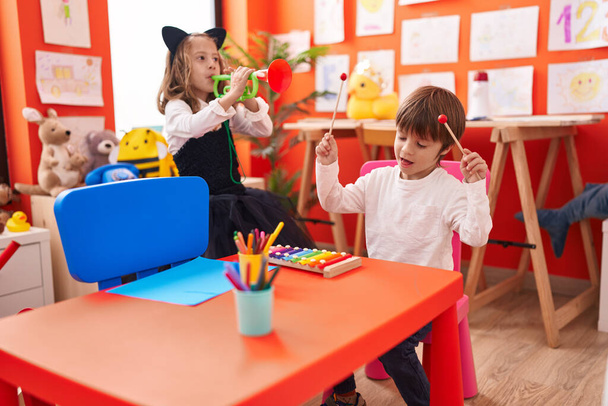 Adorable boy and girl playing xylophone and trumpet at kindergarten - Foto, Bild