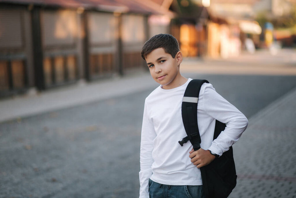 Portré boldog mosolygós tinédzser fiú fehér pulcsi hátizsák kívül. - Fotó, kép
