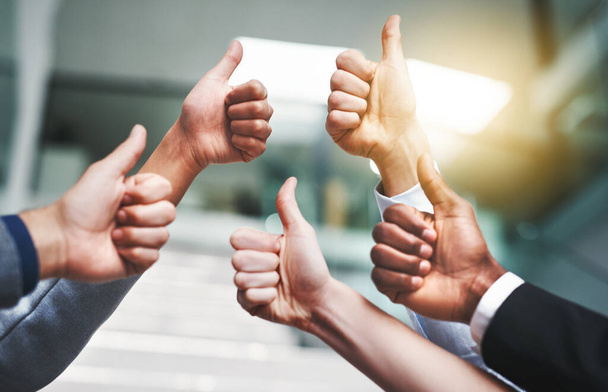 That was a great success. Closeup shot of a group of unrecognisable businesspeople showing thumbs up in an office - Foto, Imagen