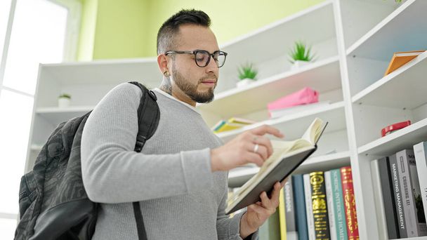 Ισπανόφωνος που στέκεται διαβάζοντας βιβλίο στο πανεπιστήμιο της βιβλιοθήκης - Φωτογραφία, εικόνα