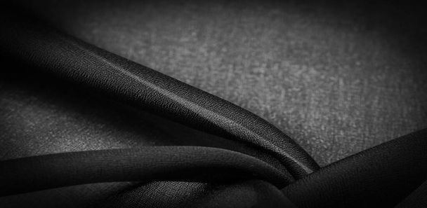 Ciemnoczarny jedwab szyfonowy to miękka przezroczysta tkanina o lekkiej chropowatości (matowa, krepowana) dzięki zastosowaniu skręconej przędzy. Tekstura tła - Zdjęcie, obraz