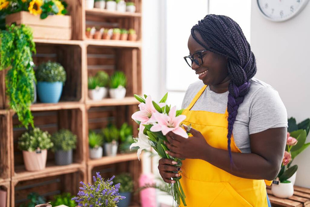 Afrikkalainen amerikkalainen nainen kukkakauppa tilalla kukkakimppu at kukkakauppa - Valokuva, kuva