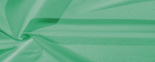 green silk. Smooth elegant green luxury silk fabric can be used as abstract background with copy space, close up. colorful texture - Foto, imagen