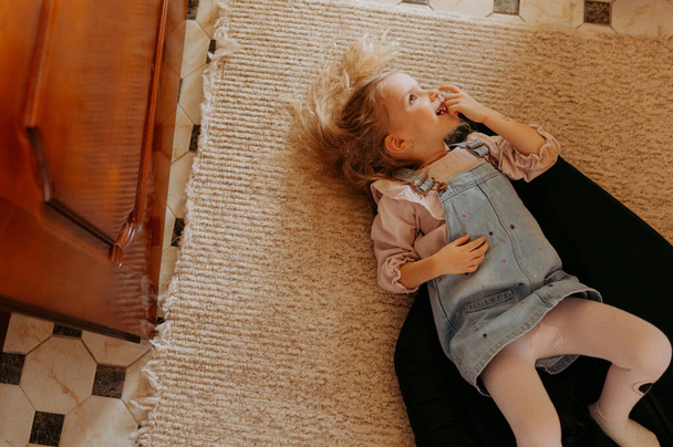 幸せな少女は床で楽しんでいる,横たわる - 写真・画像