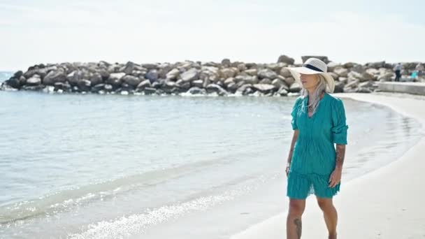 Седовласая туристка средних лет, уверенно улыбающаяся, гуляющая по пляжу - Кадры, видео