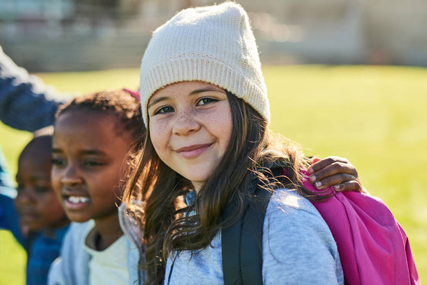 Kids will be kids. Portrait of an elementary school girl standing outside with her friends - Фото, зображення