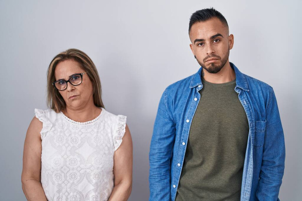 Hispanic mother and son standing together depressed and worry for distress, crying angry and afraid. sad expression.  - Foto, Bild
